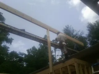 Carpenter setting a ridge beam over a new addition frame — Ice Dam Removal by Roofing Brothers in Doylesburg