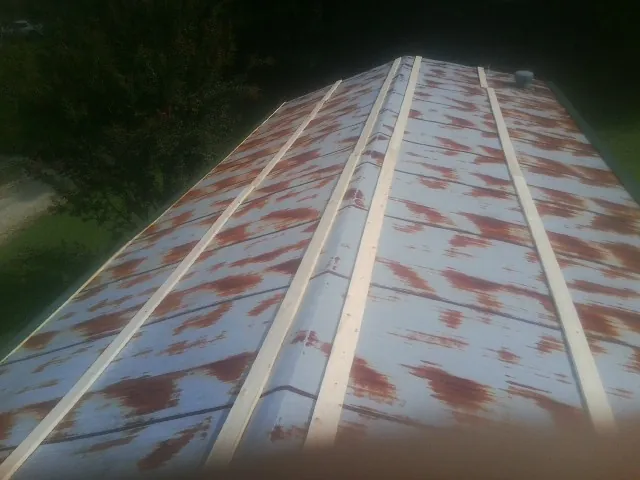 Rusted metal roof panels with new wood purlins before replacement — Storm Damage Roof Repair in Doylesburg by Roofing Brothers