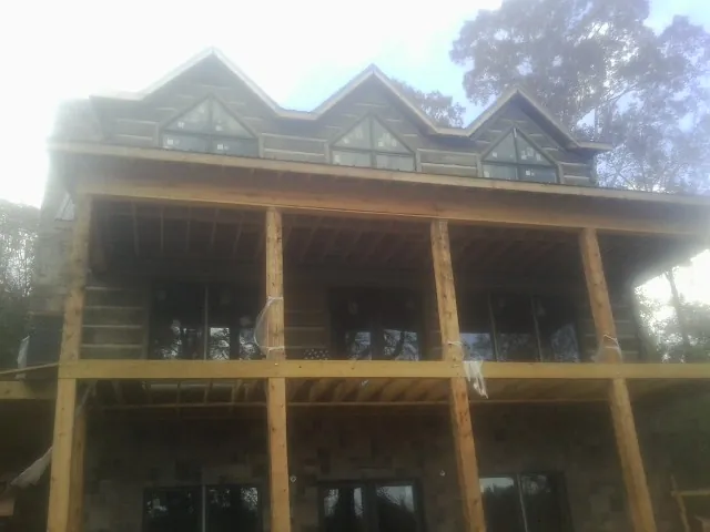Dormers and porch framing on a large log home under construction — Roof Coating work by our crew in Doylesburg