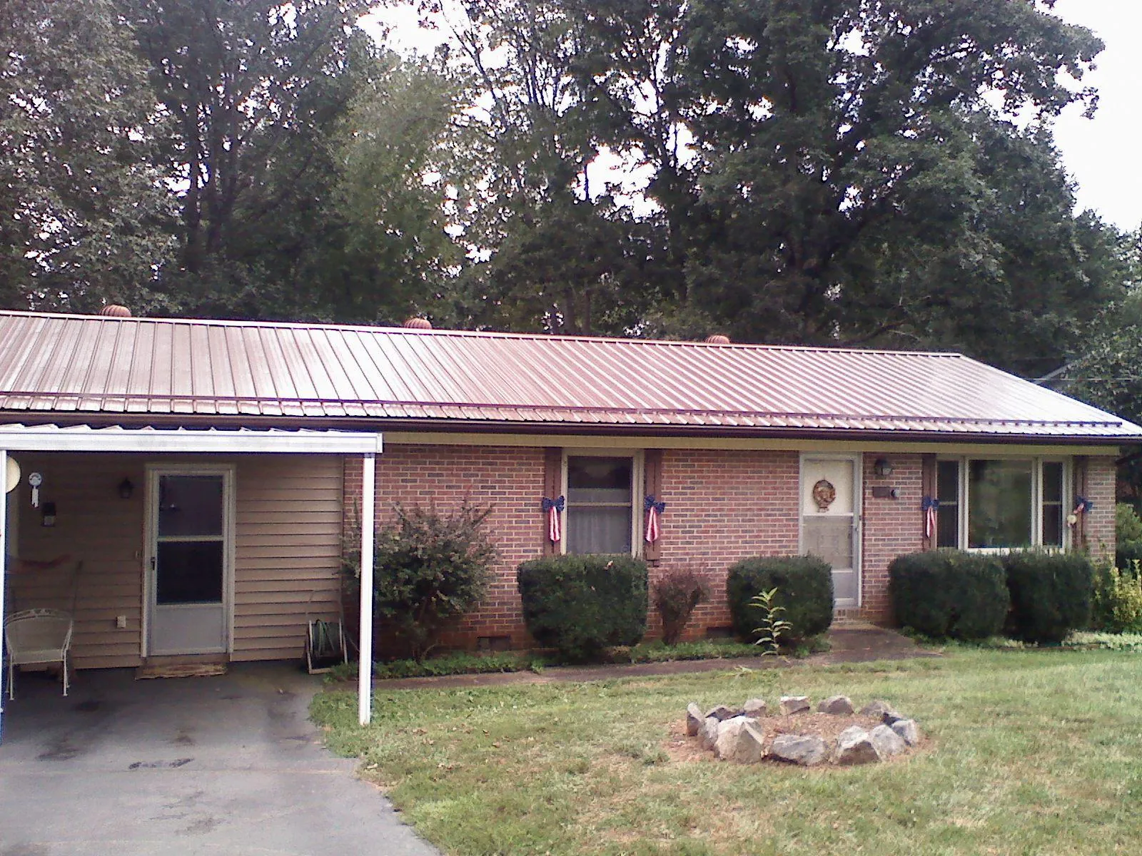Bronze metal roof and carport on a brick ranch home — Roof Repair work by our crew in Doylesburg